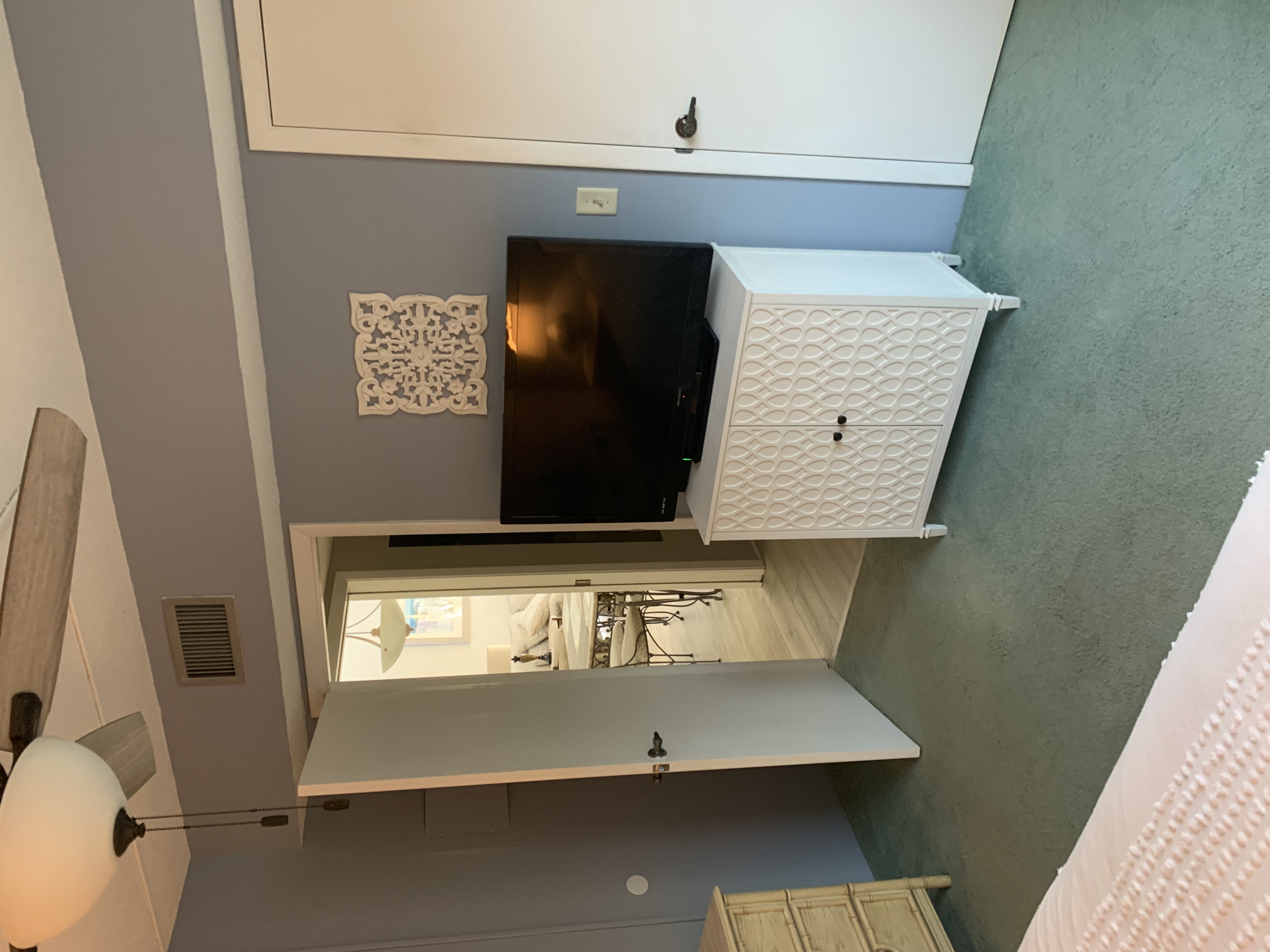 Primary bedroom television, closet, and doorway to the living room